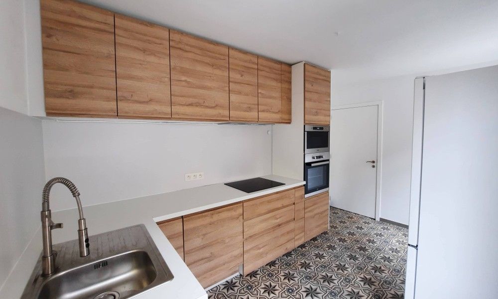 Moderne Kueche im Ferienhaus "De Zji" in De Panne an der belgischen Kueste. Voll ausgestatteter Innenbereich mit stilvollen Holzschraenken.