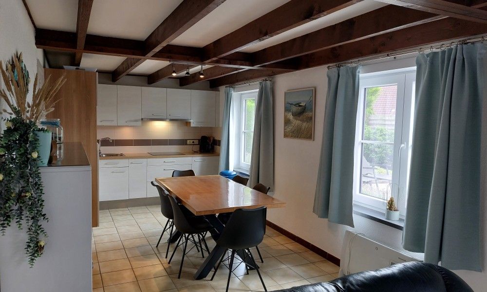 Esszimmer mit Blick auf den Garten im Ferienhaus Duinendaele 272, Adinkerke, De Panne, belgische Kueste.