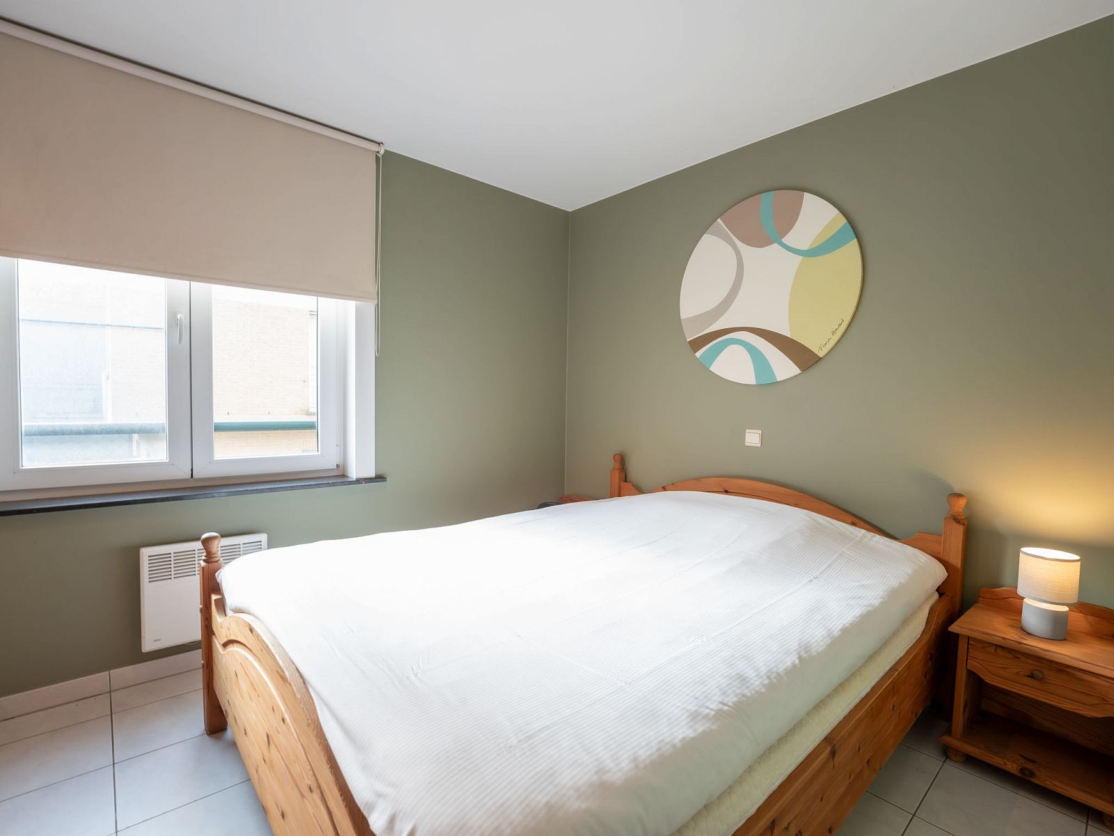 Sfeervolle slaapkamer in Appartement Flipper nabij het strand in De Haan, Belgische kust. Comfortabel verblijf met rustgevende inrichting.