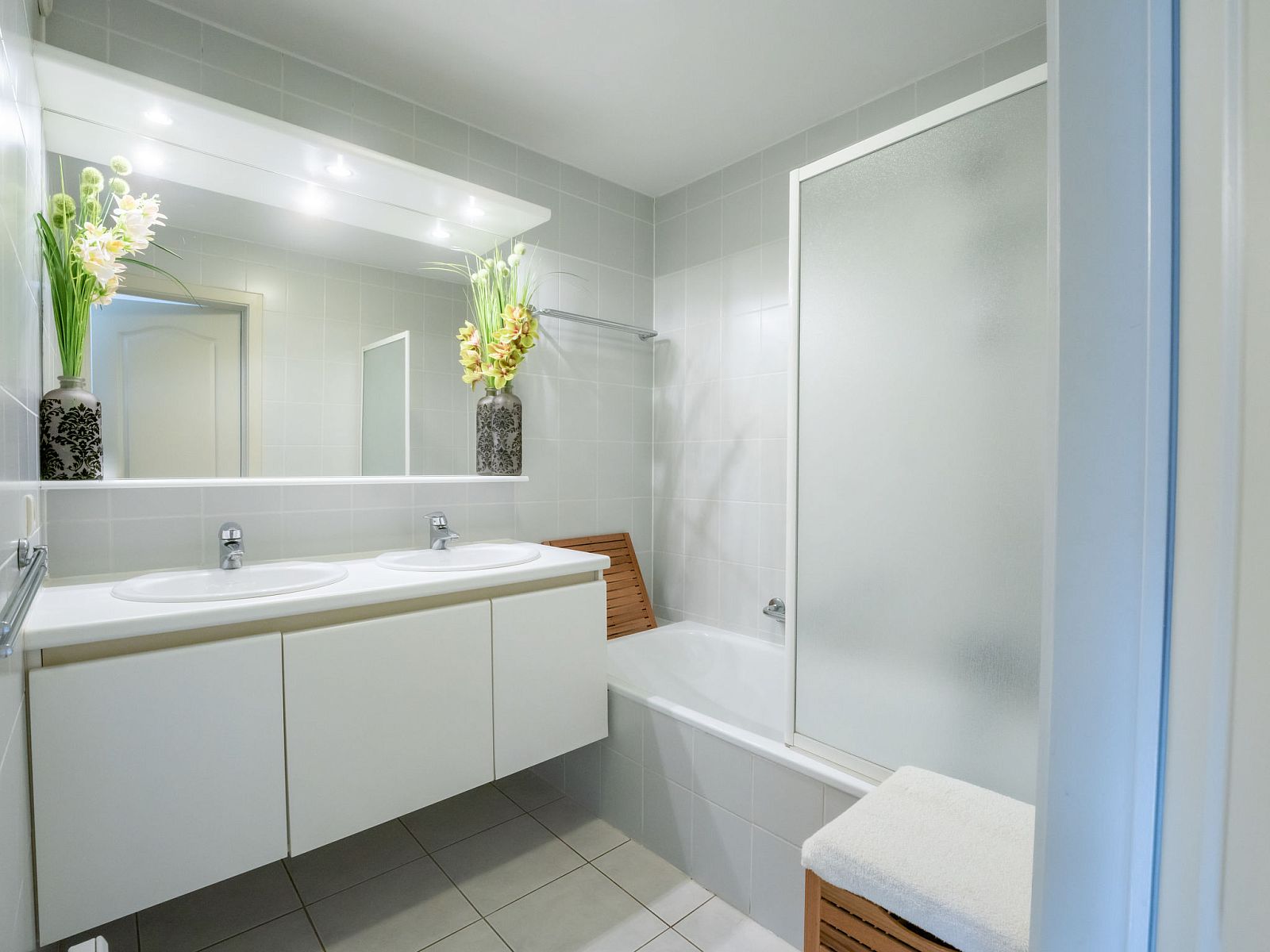 Moderne badkamer van Appartement Flipper nearby the beach in De Haan, Belgische kust, met dubbele wastafel en ruime douche.