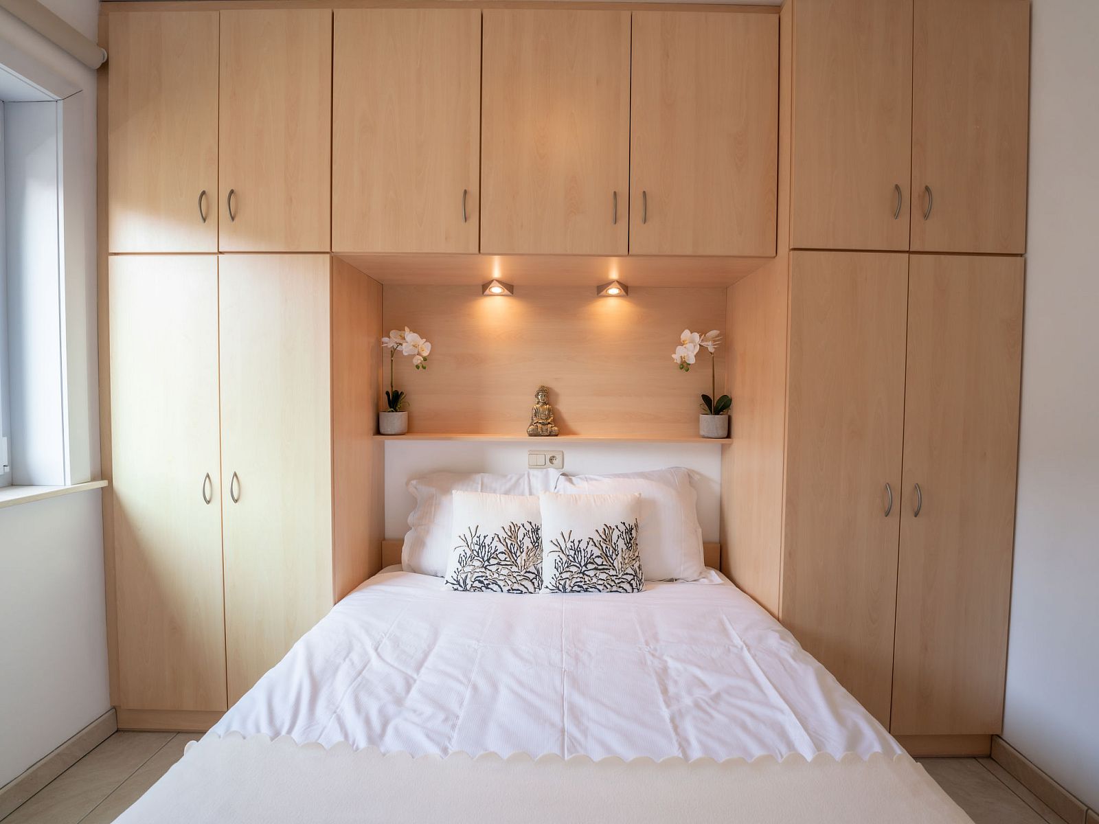 Gezellige slaapkamer in Appartement Green Garden, De Haan, Belgische kust, met ingebouwde kasten en sfeervolle verlichting.