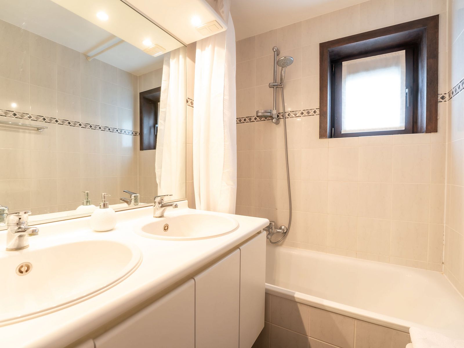 Moderne badkamer in Vakantiehuis Ingrid met dubbele wastafel, gelegen in De Haan aan de Belgische kust, perfect voor een ontspannen verblijf.