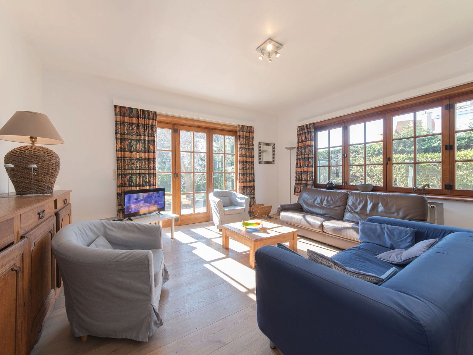 Gezellige woonkamer in Appartement Jong & Blij 2 op de begane grond met tuin in De Haan, Belgische kust. Comfortabel verblijf aan zee.