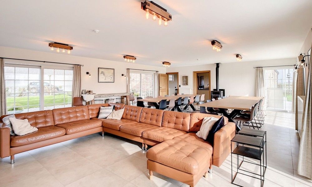 Open leefruimte in Hoeve Langhof vakantiehuis, De Haan, met veel licht en gezellige zithoek.
