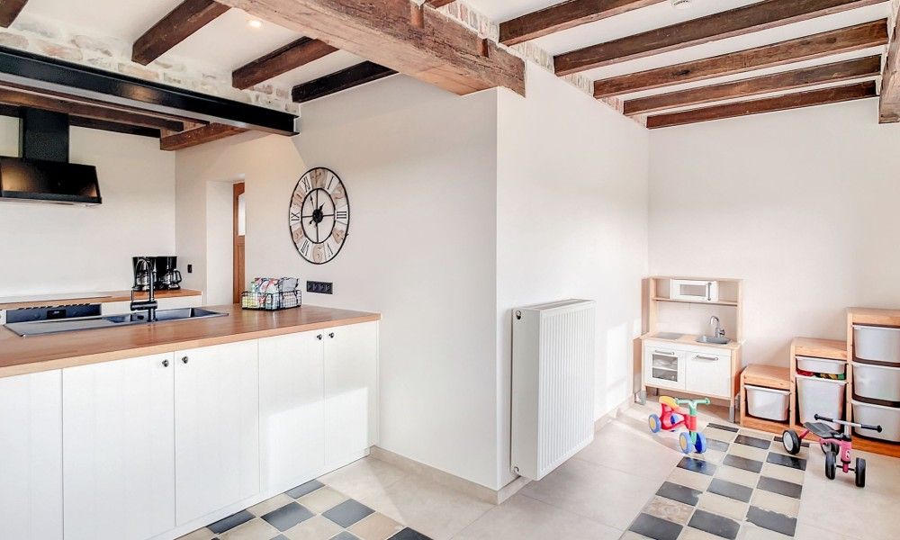 Kinderhoek in de keuken van Hoeve Langhof vakantiehuis, De Haan, met speelgoed en speelruimte.
