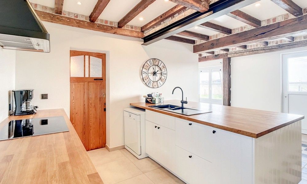 Stijlvolle keuken met houten afwerking in Hoeve Langhof vakantiehuis, De Haan, Belgische kust.