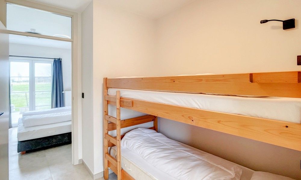 Gezellige kinderkamer met stapelbed in Hoeve Langhof vakantiehuis, De Haan, ideaal voor gezinnen.
