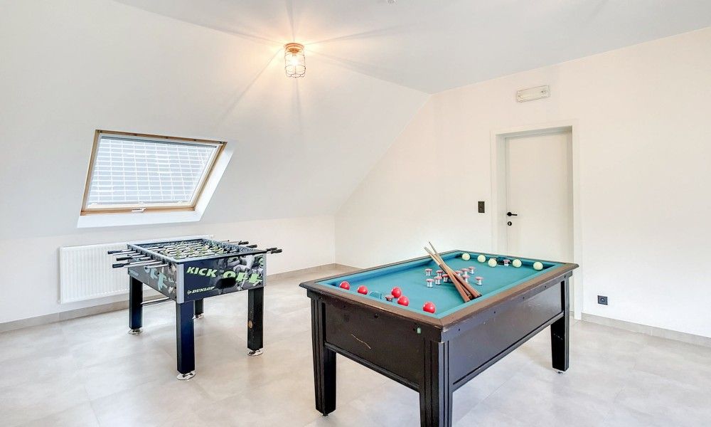 Speelkamer met tafelvoetbal en pooltafel in Hoeve Langhof vakantiehuis, De Haan.