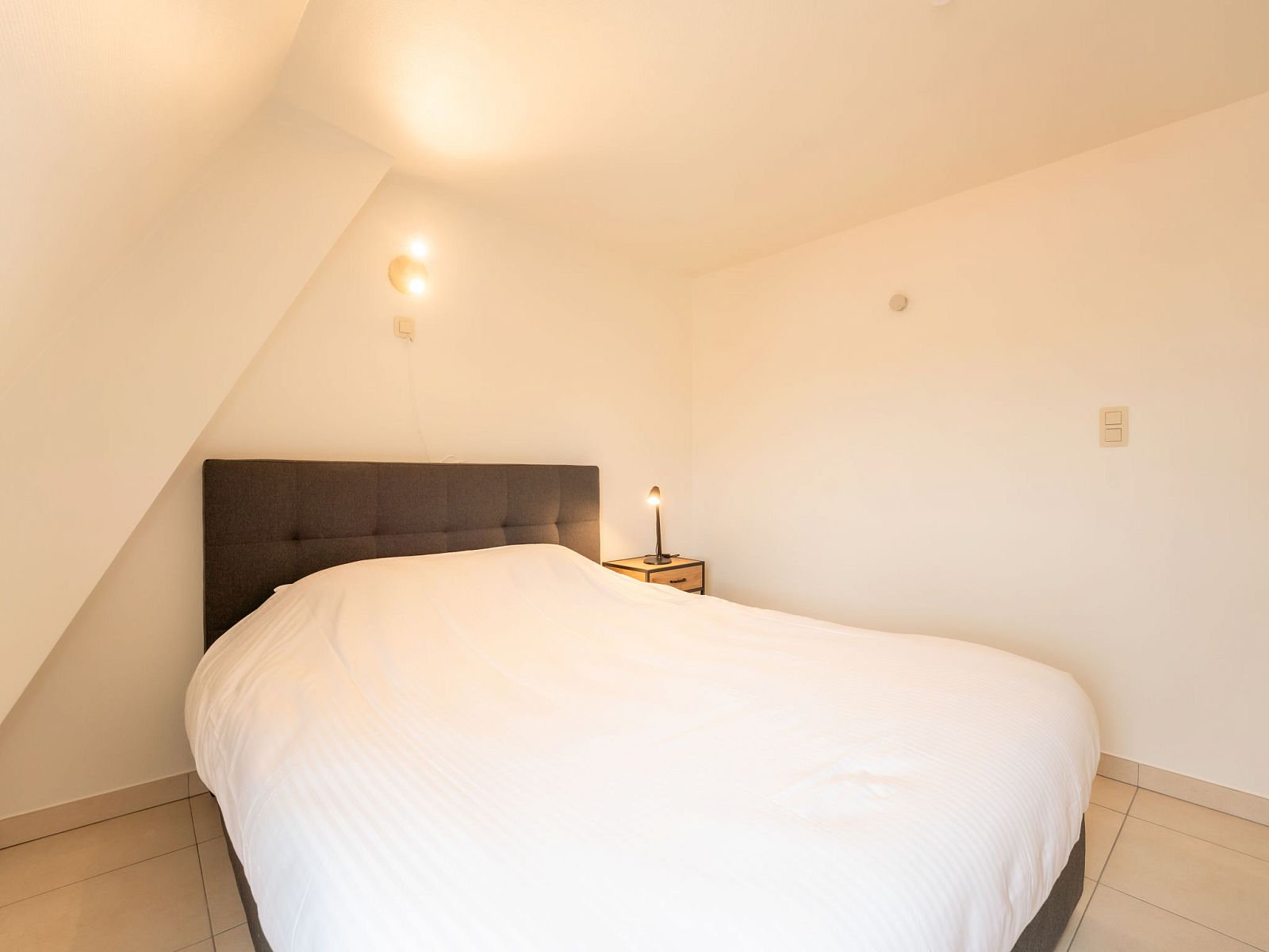 Comfortabele slaapkamer in Appartement Koekoeksnest Penthouse at the beach, De Haan, Belgische kust, ideaal voor ontspanning aan zee.