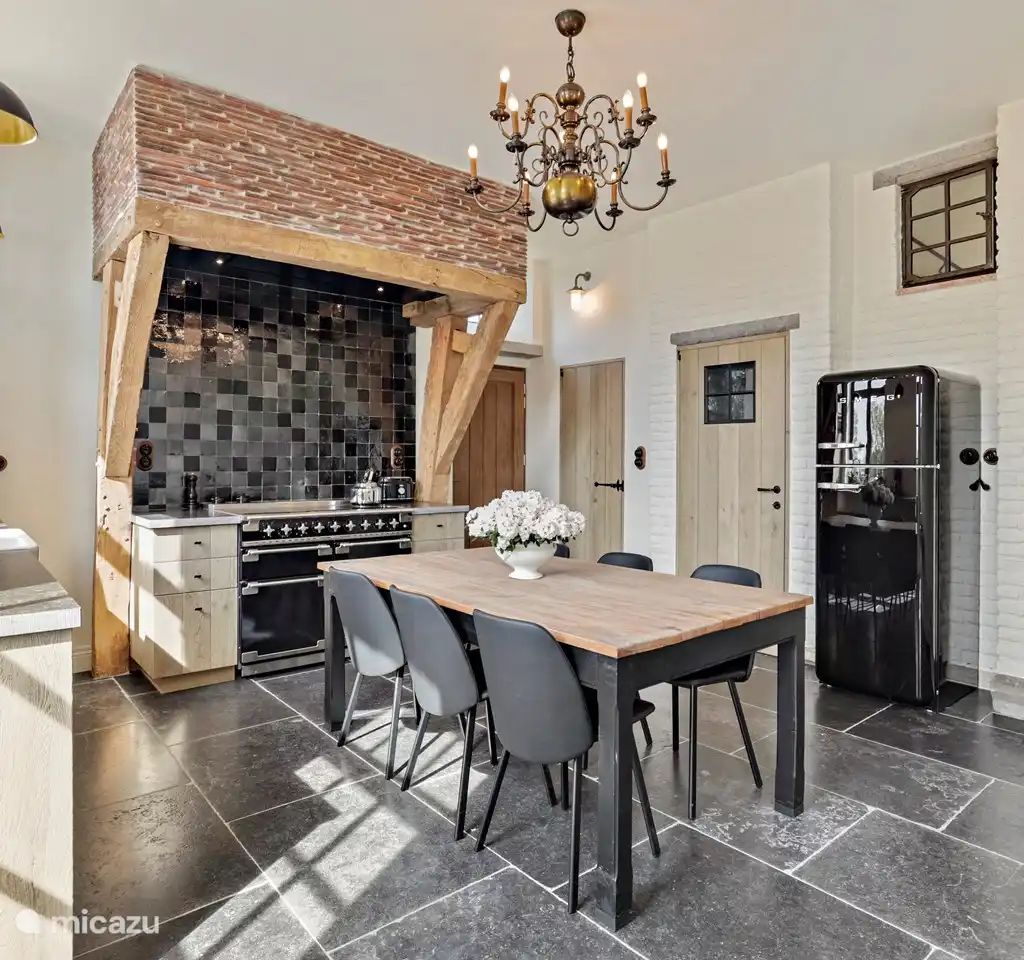 Gezellige keuken in Huis Potaerde, een vakantiehuis in Brussel, met een rustieke eettafel en authentieke details voor een warme sfeer.