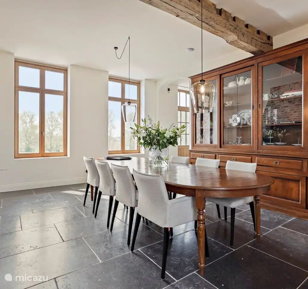 Elegante eetkamer in Huis Potaerde, een vakantiehuis in Brussel, Belgie, met veel natuurlijk licht en stijlvolle inrichting.