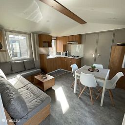 Gemuetliches Wohnzimmer des Ferienchalets "Azalee" in Bruegge, Westflandern, mit moderner Kueche und Essbereich.
