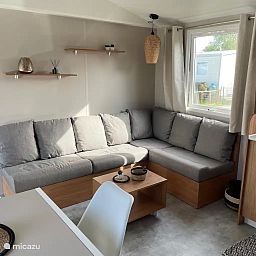 Gemuetliches Wohnzimmer von "Vakantieverhuur Azalee", einem Chalet in Bruegge, Westflandern, mit einer bequemen Sitzecke und viel Tageslicht.