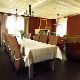 Aussenansicht des Ferienhauses Hof ter Harte, Ypern, Westflandern, mit roten Akzenten und bluehenden Hortensien.