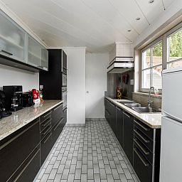 Gezellige eetruimte in vakantiehuis Floribert, Nieuwpoort-Bad, met uitzicht op groene tuin, ideaal voor familiebijeenkomsten in West-Vlaanderen.