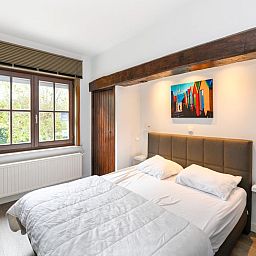 Gezellige slaapkamer in vakantiehuis Floribert, Nieuwpoort-Bad, met comfortabel tweepersoonsbed en rustgevend uitzicht op de tuin.