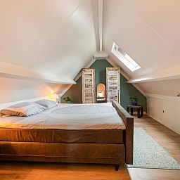 Gemuetliches Schlafzimmer in der Villa Belle Haan, einem Ferienhaus in De Haan, Westflandern, mit bequemem Doppelbett und stimmungsvoller Beleuchtung.