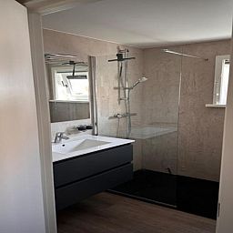 Modernes Badezimmer in der Villa Belle Haan, einem Ferienhaus in De Haan, Westflandern, mit stilvoller Dusche und Waschbecken.