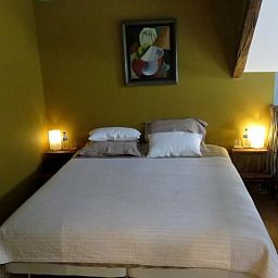 Gemuetliches Schlafzimmer im Ferienhaus in Dranouter, Westflandern, Belgien, mit stimmungsvoller Beleuchtung und Kunst an der Wand.