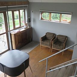 Gemuetliches Wohnzimmer im Ferienhaus in Dranouter, Westflandern, mit Blick auf die gruene Umgebung und gemuetlicher Sitzecke.