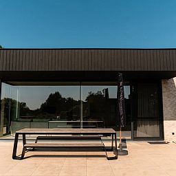 Terrasse des Ferienhauses in Heuvelland, Westouter, mit moderner Einrichtung und Blick auf die Natur in Westflandern, Belgien.