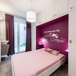 Sfeervolle slaapkamer in Apollo Gelijkvloers vakantiehuis in Koksijde, West-Vlaanderen, met moderne inrichting en inspirerende wandtekst.