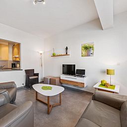 Gezellige woonkamer van vakantiehuis Azcona Twee in Koksijde, West-Vlaanderen, Belgie, met moderne inrichting en comfortabele zitplaatsen.