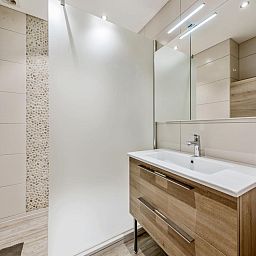 Moderne badkamer in Azcona Twee vakantiehuis, Koksijde, West-Vlaanderen met stijlvolle wastafel en ruime douche.
