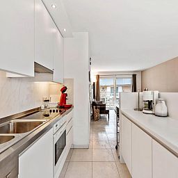 Moderne keuken in Klokjesbloem Gelijkvloers vakantiehuis, Koksijde, West-Vlaanderen, met uitzicht op lichte woonruimte.