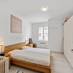 Sfeervolle slaapkamer in Klokjesbloem Gelijkvloers, vakantiehuis in Koksijde, West-Vlaanderen, met comfortabel bed en natuurlijk licht.