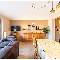 Gezellige woonkamer in vakantiehuis Cortina tweede, Koksijde, West-Vlaanderen met comfortabele zitruimte en eetgedeelte.