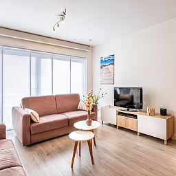 Gezellige woonkamer van Gaston Lejeune tweede vakantiehuis in Koksijde, West-Vlaanderen met comfortabele banken en moderne inrichting.