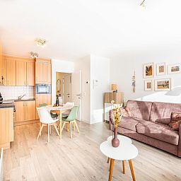 Gezellige woonkamer van Gaston Lejeune tweede vakantiehuis in Koksijde, West-Vlaanderen, met moderne keuken en comfortabele zithoek.