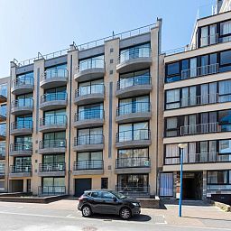 Ruime woonkamer in Guernsey eerste vakantiehuis, Koksijde, Belgie. Gezellige eethoek met veel natuurlijk licht en stijlvolle inrichting.