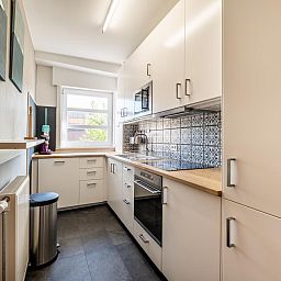 Moderne keuken in Juvamy gelijkvloers, een vakantiehuis in Koksijde, West-Vlaanderen, Belgie, met stijlvolle inrichting en veel natuurlijk licht.