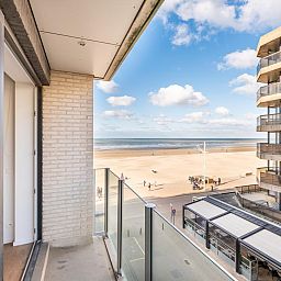 Lichte woonkamer van vakantiehuis De Dijk derde in Koksijde, West-Vlaanderen, met panoramisch uitzicht op het strand en de zee.
