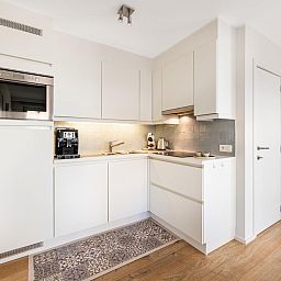 Lichte woonkamer van De Dijk derde vakantiehuis in Koksijde, West-Vlaanderen, met moderne inrichting en grote ramen voor een ruimtelijk gevoel.