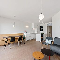 Moderne binnenruimte van De Meeuwen derde vakantiehuis in Koksijde, West-Vlaanderen, met stijlvolle keuken en eetgedeelte.