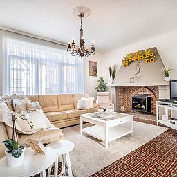 Gezellige woonkamer in vakantiehuis Porpoises, Koksijde, West-Vlaanderen, met comfortabele zithoek en sfeervolle open haard.