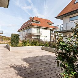 Geniet van het ruime terras bij Tinou Gelijkvloers vakantiehuis in Koksijde, West-Vlaanderen, omgeven door moderne architectuur.