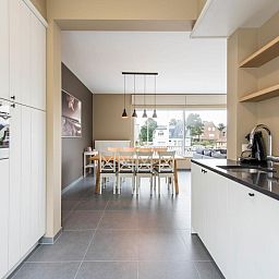 Stylish kitchen and dining area in La Vachequirit vacation home, Koksijde, West Flanders, overlooking a quiet residential area.