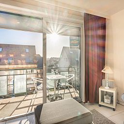 Zonnig balkon van vakantiehuis Pablito trois in Koksijde, West-Vlaanderen met uitzicht op rustige omgeving.