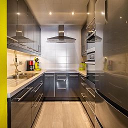 Moderne keuken in vakantiehuis Zeezicht GV, Koksijde, West-Vlaanderen. Stijlvolle inrichting met roestvrijstalen apparatuur en heldere accenten.