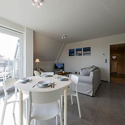 Stijlvolle woonkamer van Bon Accueil tweede vakantiehuis in Koksijde, West-Vlaanderen, met modern interieur en ruim terrasuitzicht.
