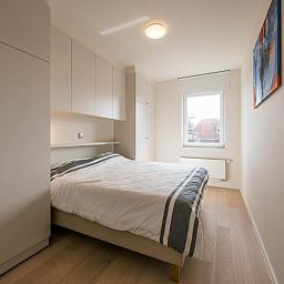 Sfeervolle slaapkamer in Bon Accueil tweede vakantiehuis, Koksijde, West-Vlaanderen, met moderne inrichting en natuurlijk licht.