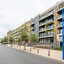 Paco derde vakantiehuis in Koksijde, West-Vlaanderen, biedt een modern balkon met uitzicht op een rustige straat en groene omgeving.