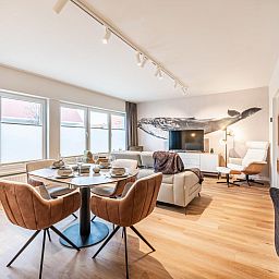 Stijlvolle woonkamer in vakantiehuis Bon Plan in Koksijde, West-Vlaanderen, met modern interieur en veel natuurlijk licht.