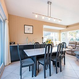 Gezellige eetkamer in vakantiehuis Mallory, Koksijde, met veel natuurlijk licht en comfortabele zithoek in West-Vlaanderen, Belgie.