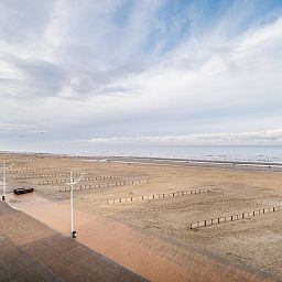 Uitzicht op het strand bij Vitelli vierde vakantiehuis in Koksijde, West-Vlaanderen, met een panoramisch zeezicht en uitgestrekte zandstranden.