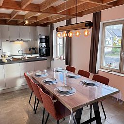 Gezellige eetkamer en keuken in vakantiehuis Westhinder II H23, Koksijde, West-Vlaanderen, met moderne inrichting en uitzicht op de tuin.